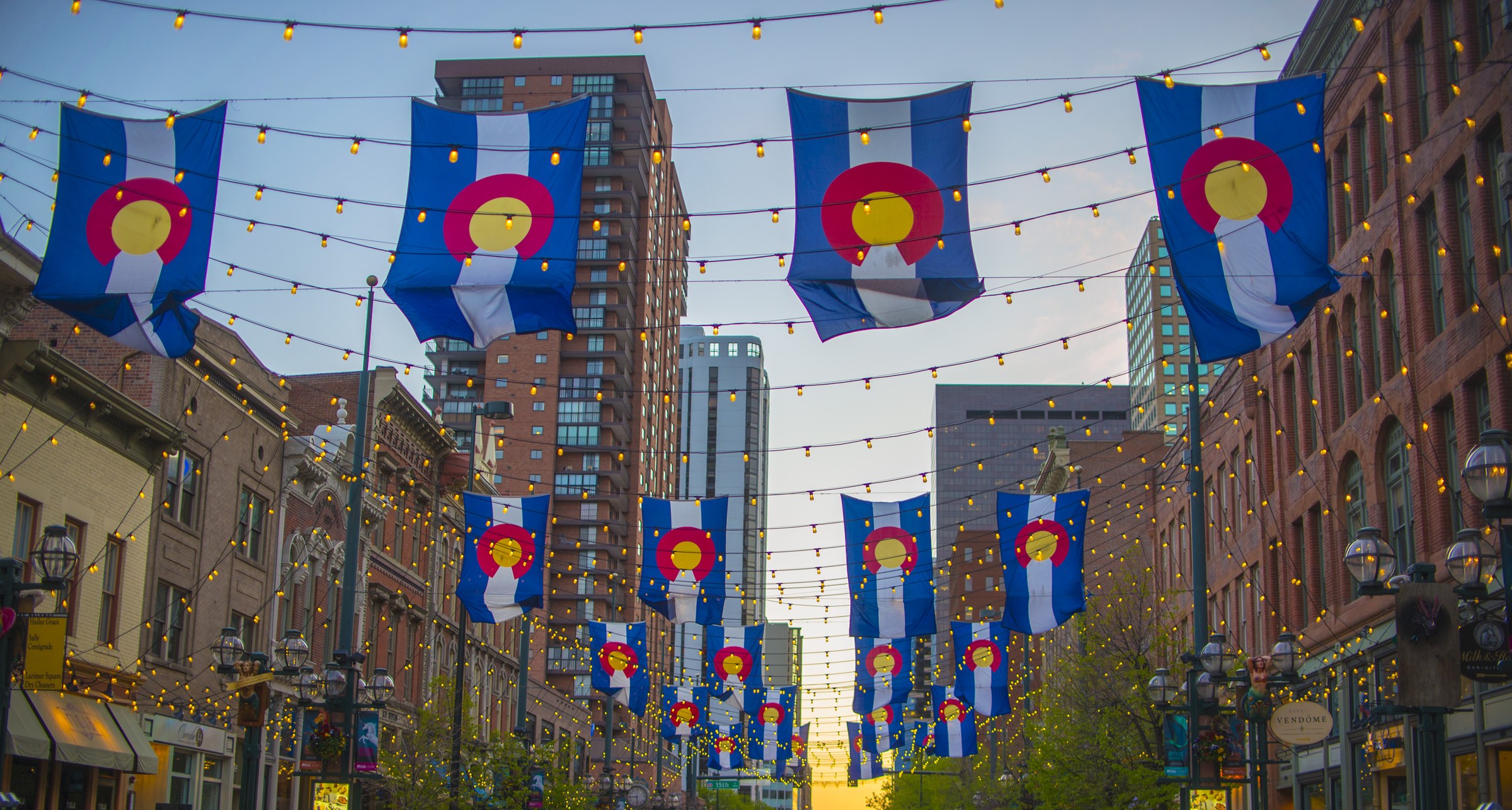 Colorado flags and string lights over Larimer Square, Denver